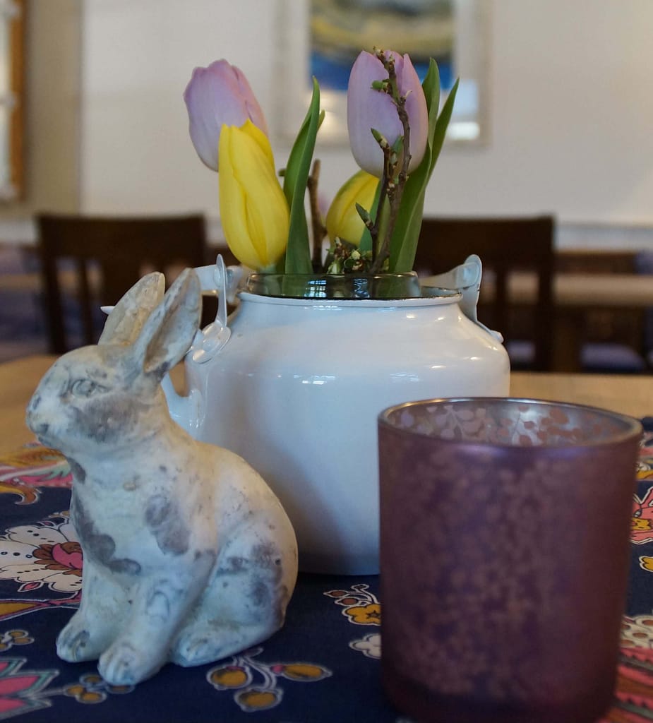 Osterdekoration auf einem Tisch mit einem Hasen und Tulpen in gelb und lila in der Panorama Pension Ahrklause Dernau.